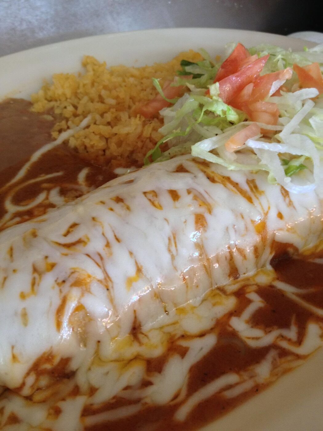 Cheesy Chapala burrito with rice, beans and salad