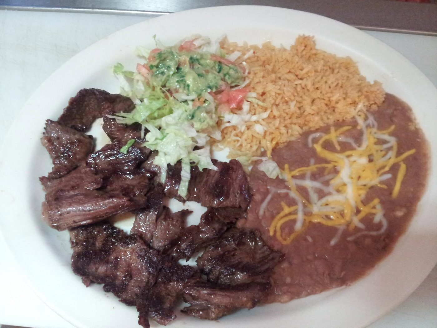Carne asada served with rice, beans and salad
