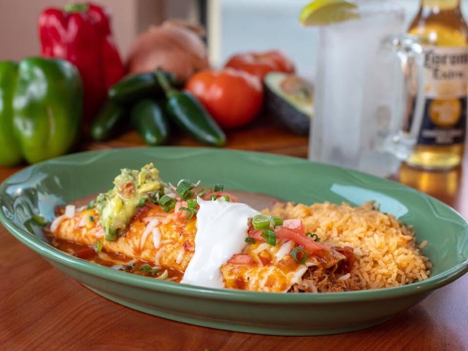 Enchiladas served with rice and fresh toppings